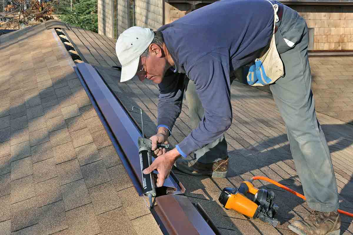 Roofer installing ridge vents on a roof