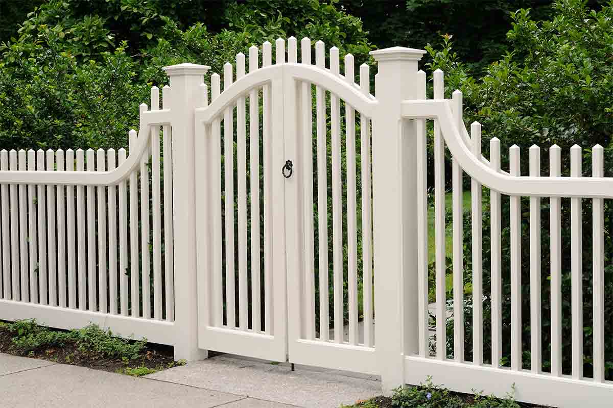 White picket fence with a curved-top gate