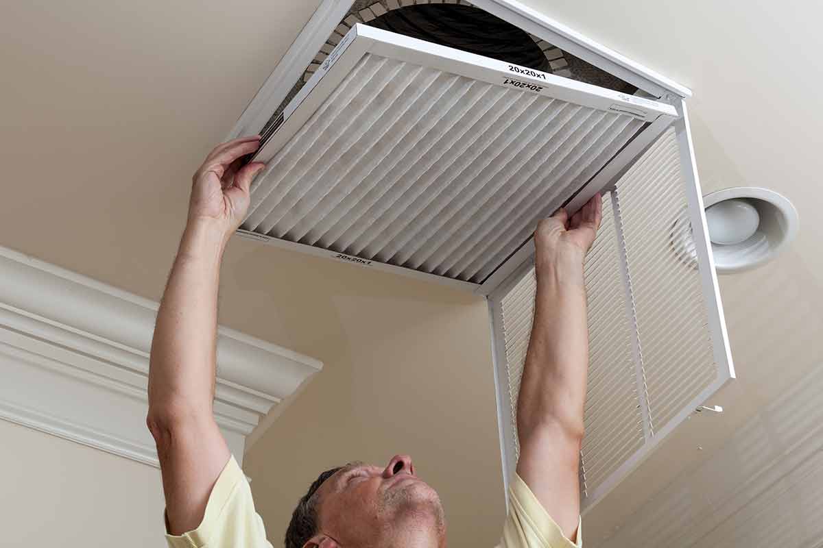 man changing air filter for HVAC system