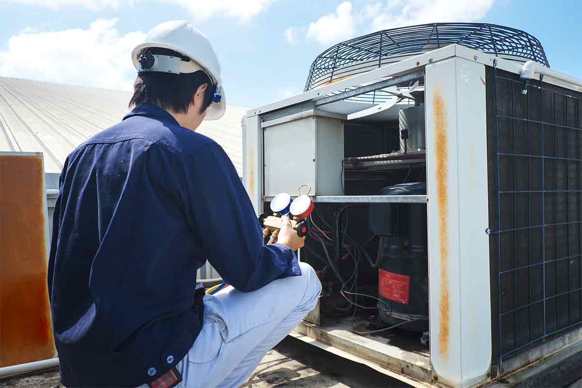 HVAC technician repairs air conditioner unit