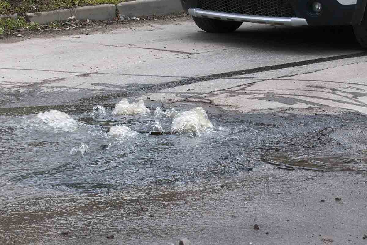 Water from broken water main flooding road