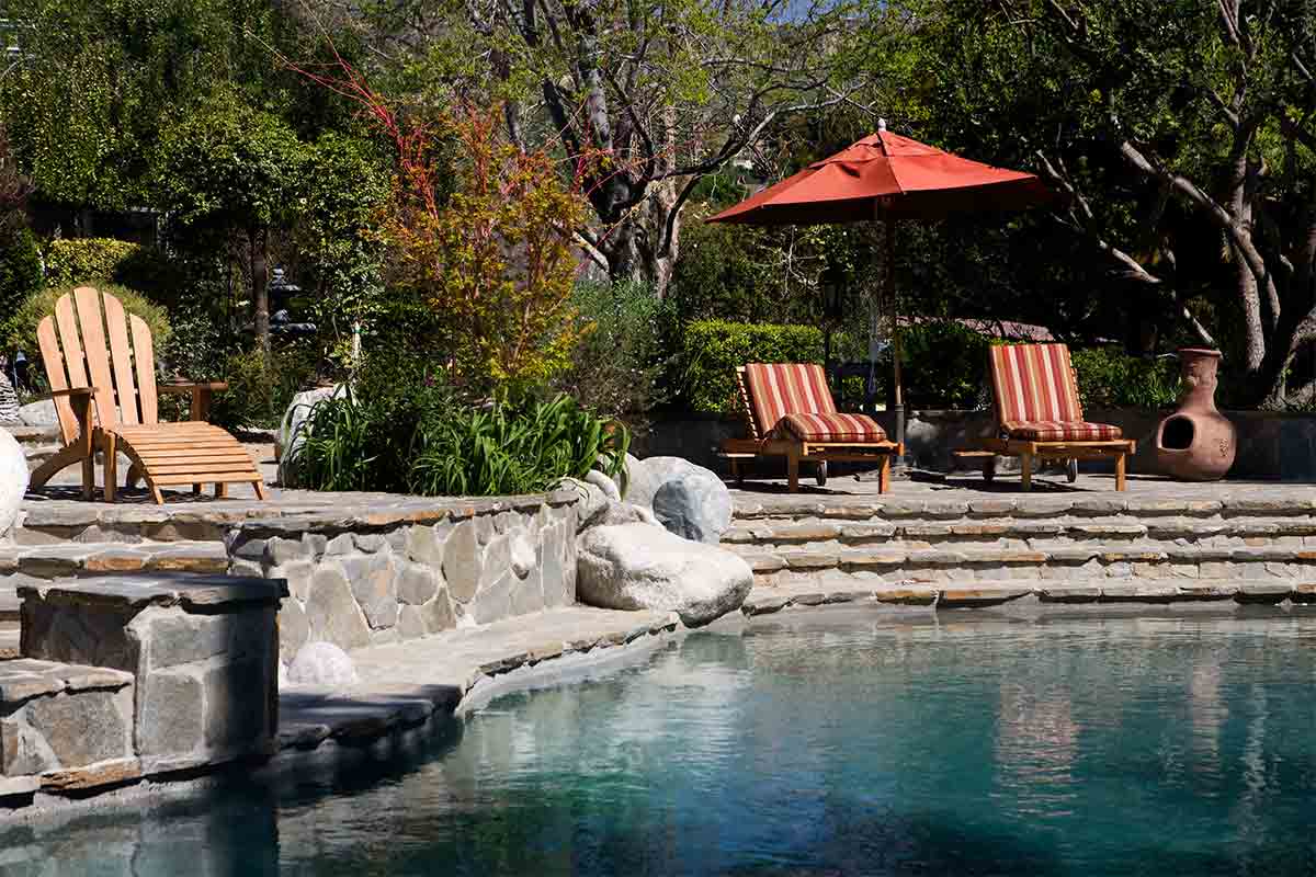 saltwater pool with rock surround and patio furniture