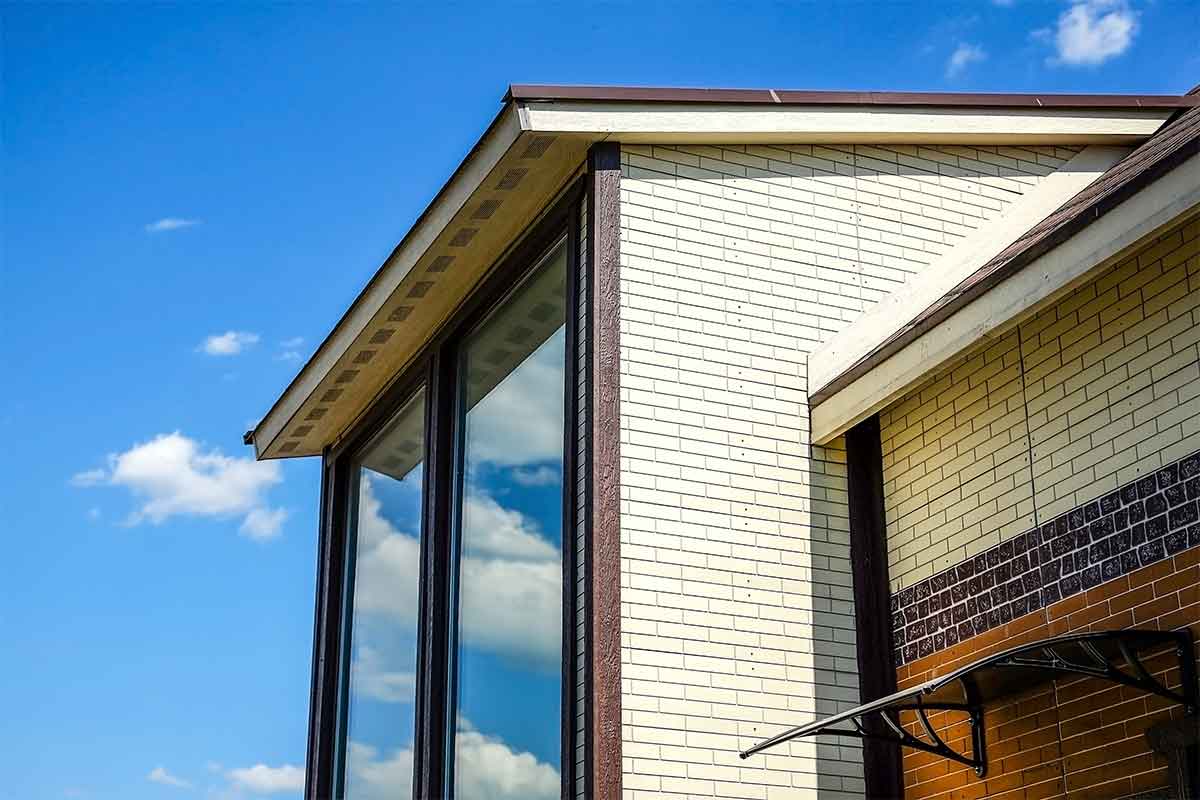 close-up of large reflective windows on a brick house