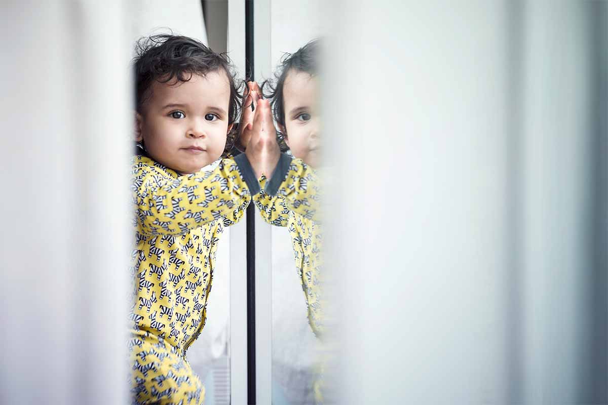 baby leaning against glass