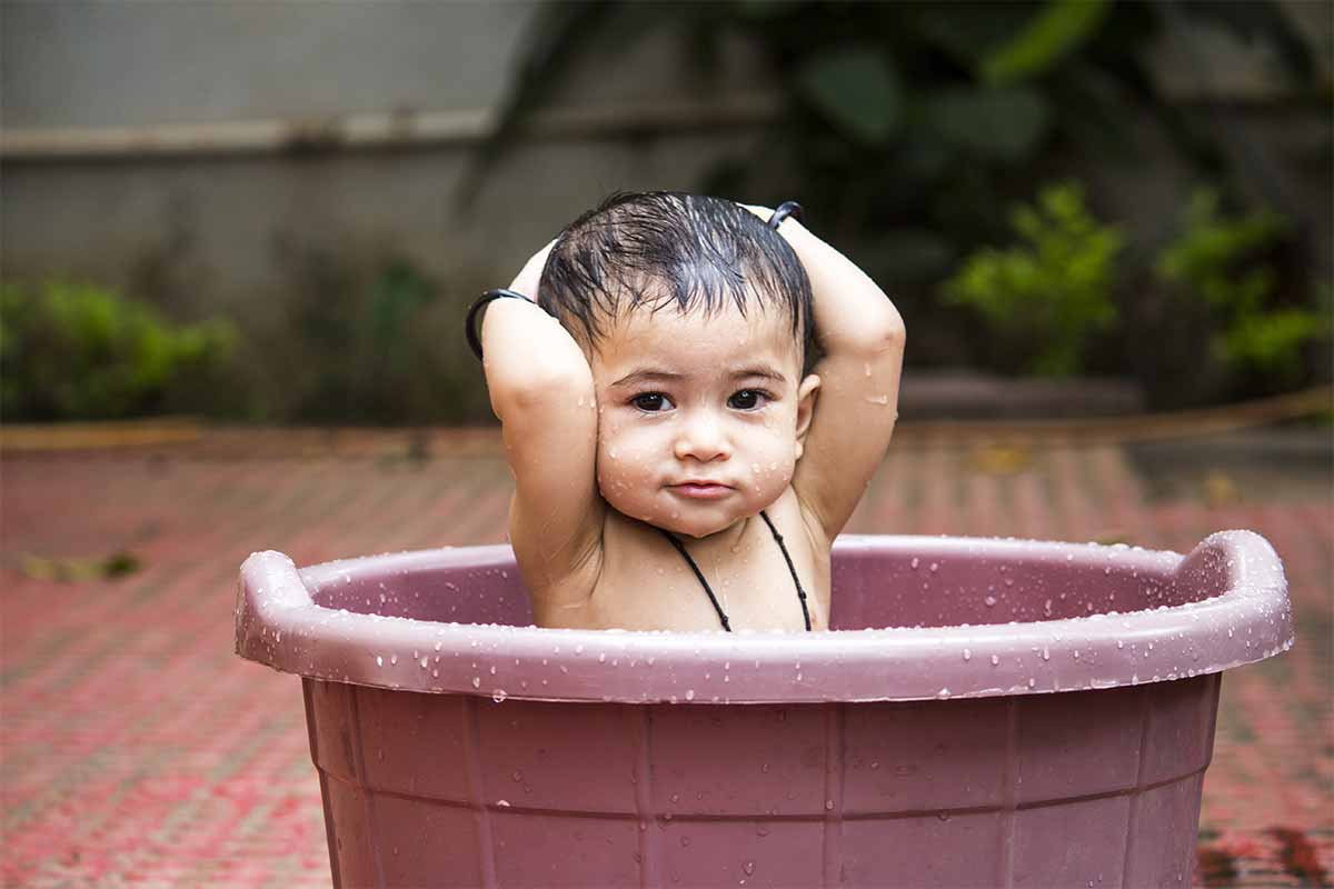 baby sitting in bucket of water