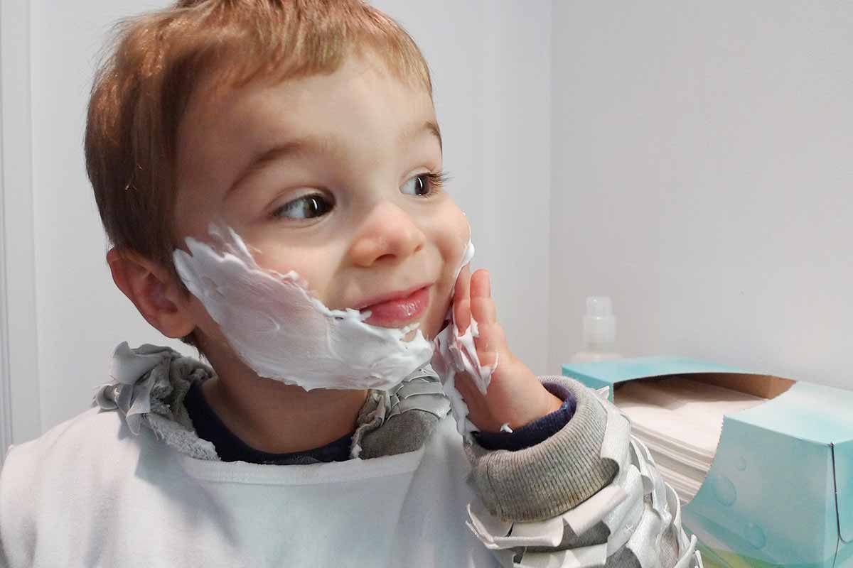 child putting shaving cream on face