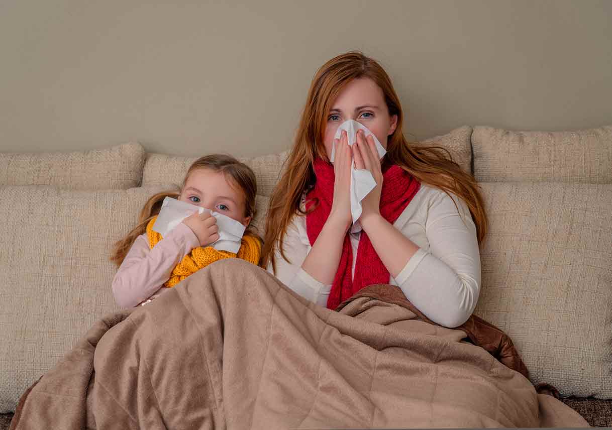 mom and daughter with flu on couch