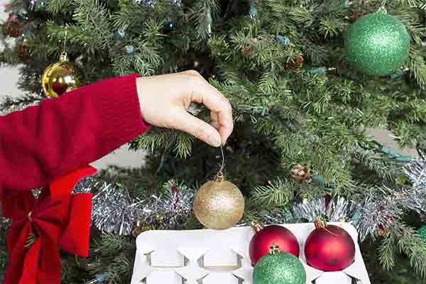 hand putting ornaments into storage