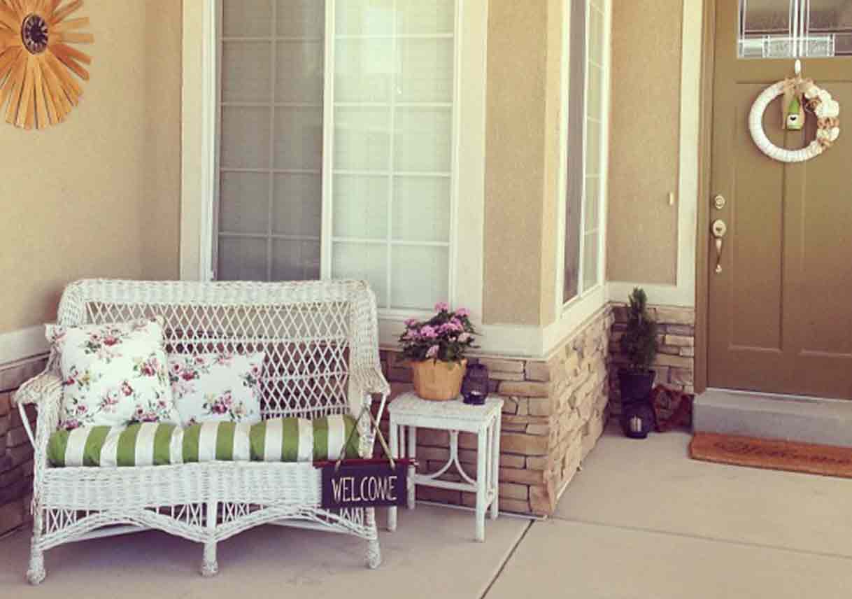 porch with white wicker furniture and colorful cushions