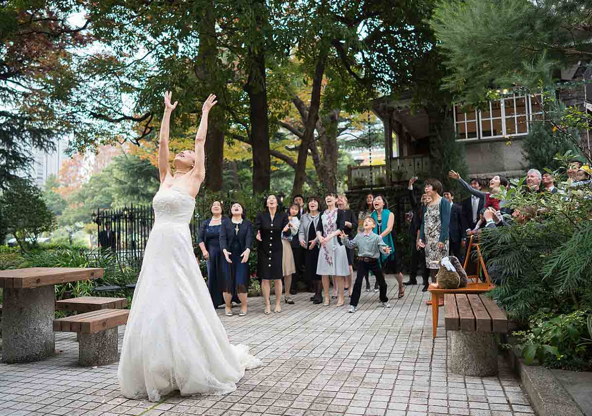 bride tosses bouquet to crowd at outdoor wedding