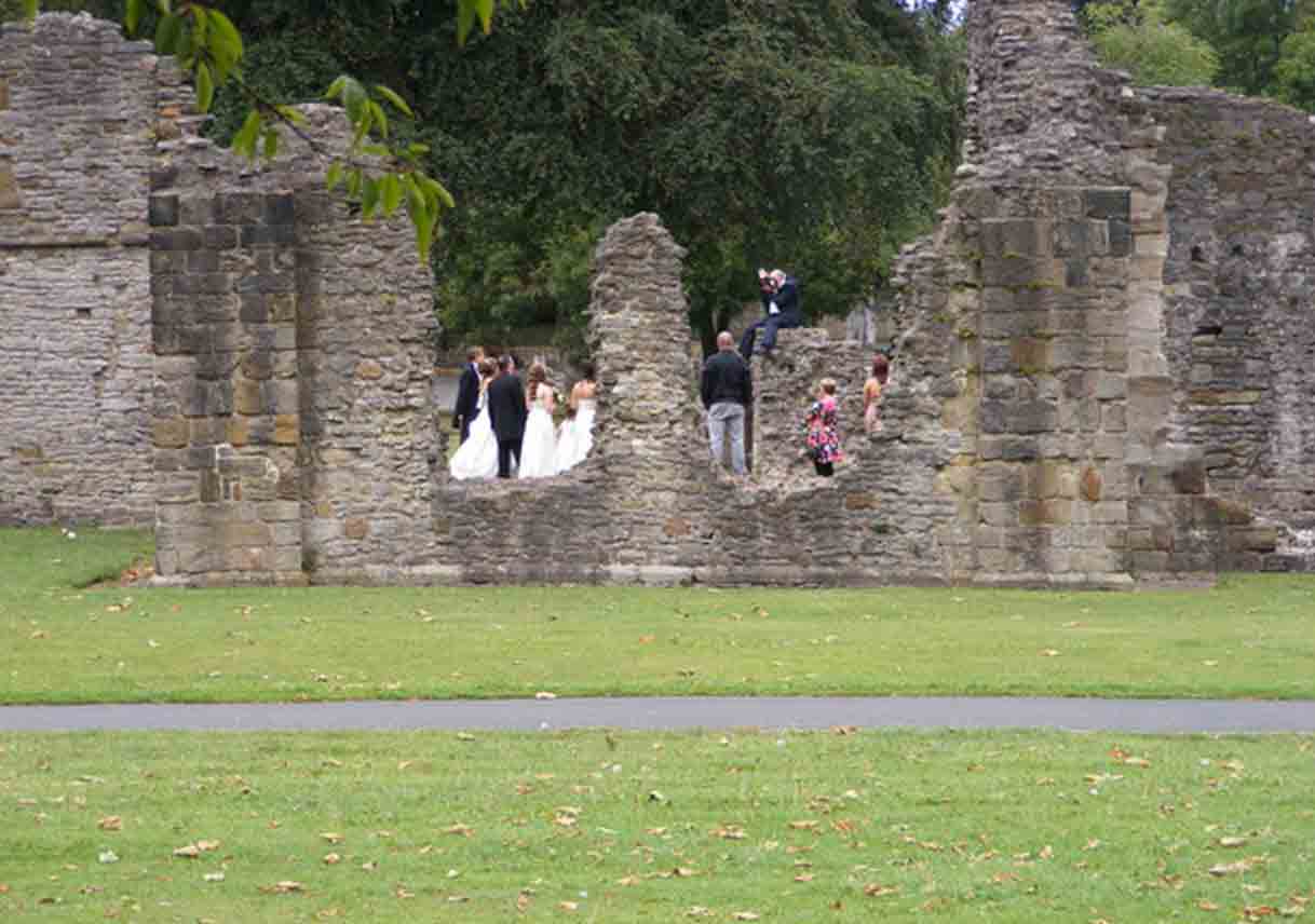 wedding party stands in center of old ruins