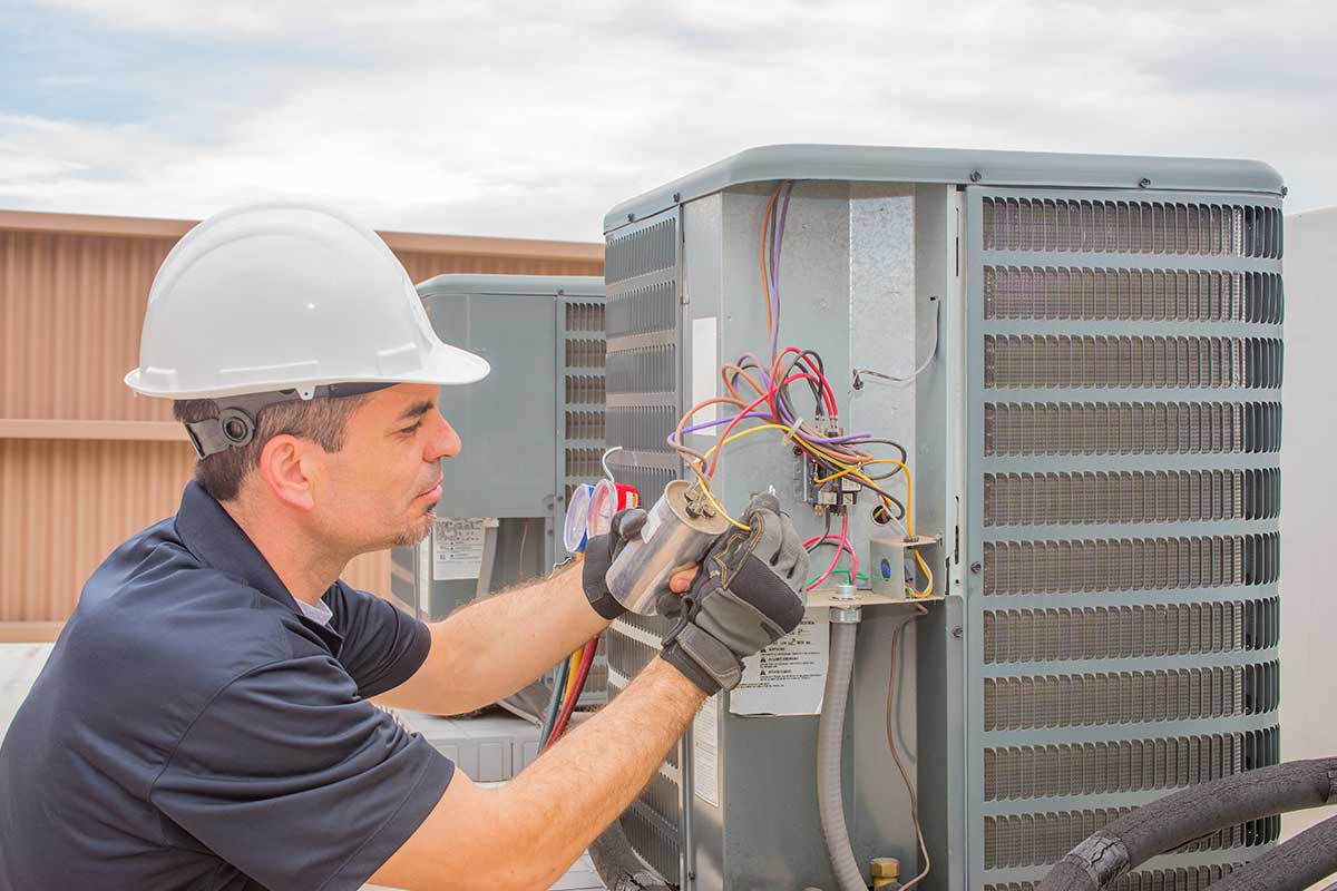 HVAC technician fixing a broken condenser