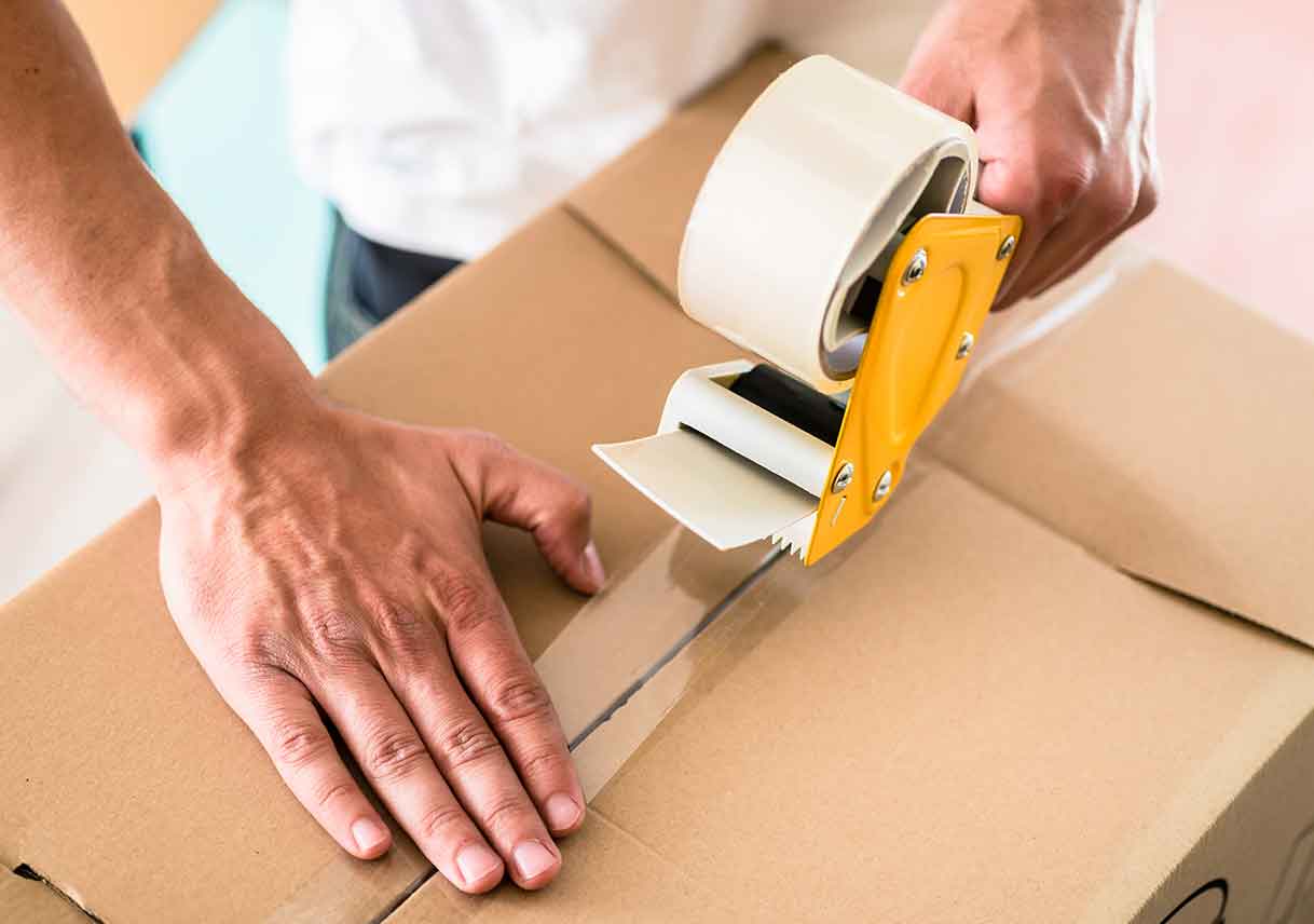 hands closing cardboard box with packing tape