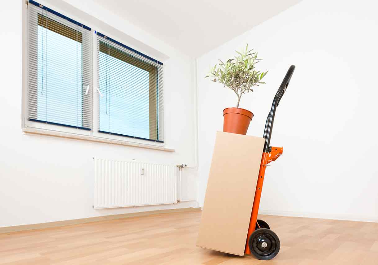 handtruck loaded with a box in an empty room