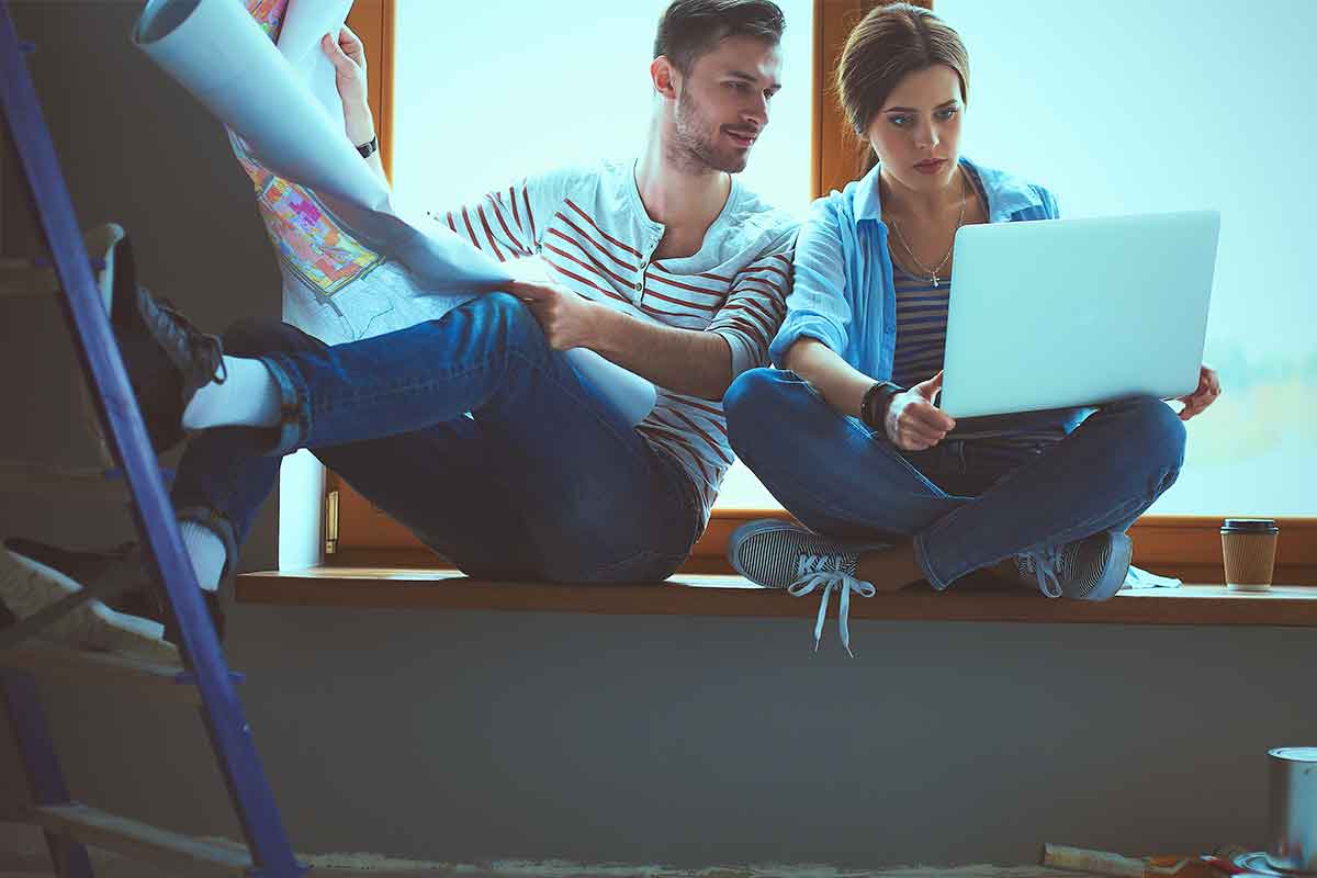 couple looking at a computer and blueprints