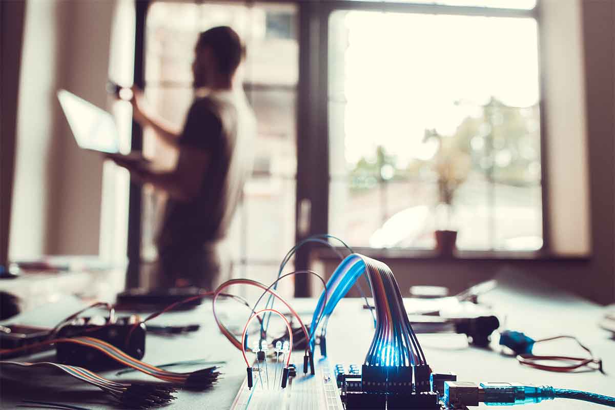 wiring in foreground with man working in back