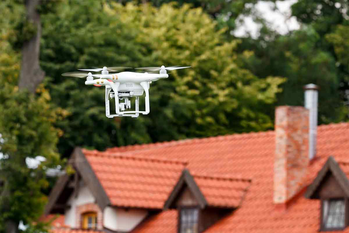 drone flying in front of a home