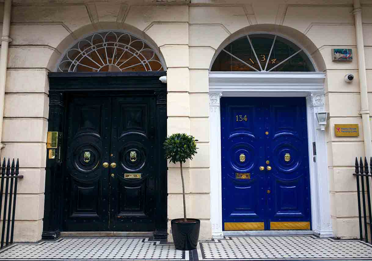 Black door with elaborate fanlight and blue door with simple fanlight