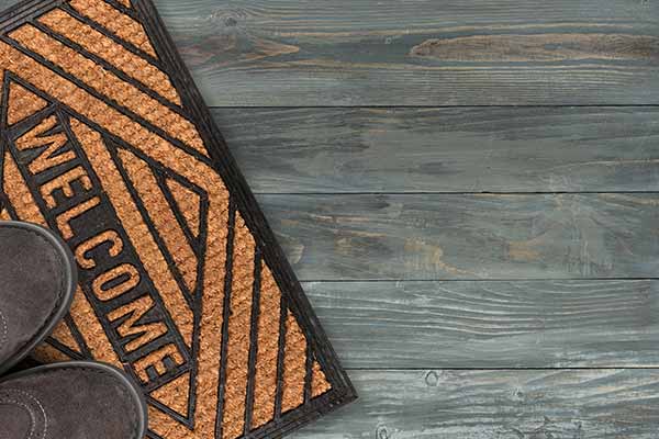 shoes and welcome mat on wooden deck