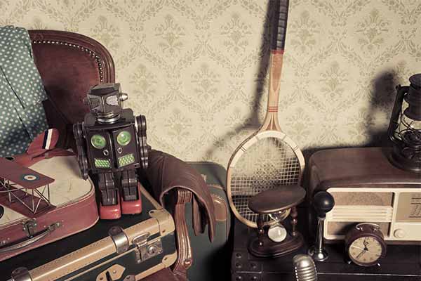 Assorted vintage items stacked in the attic with retro wallpaper background