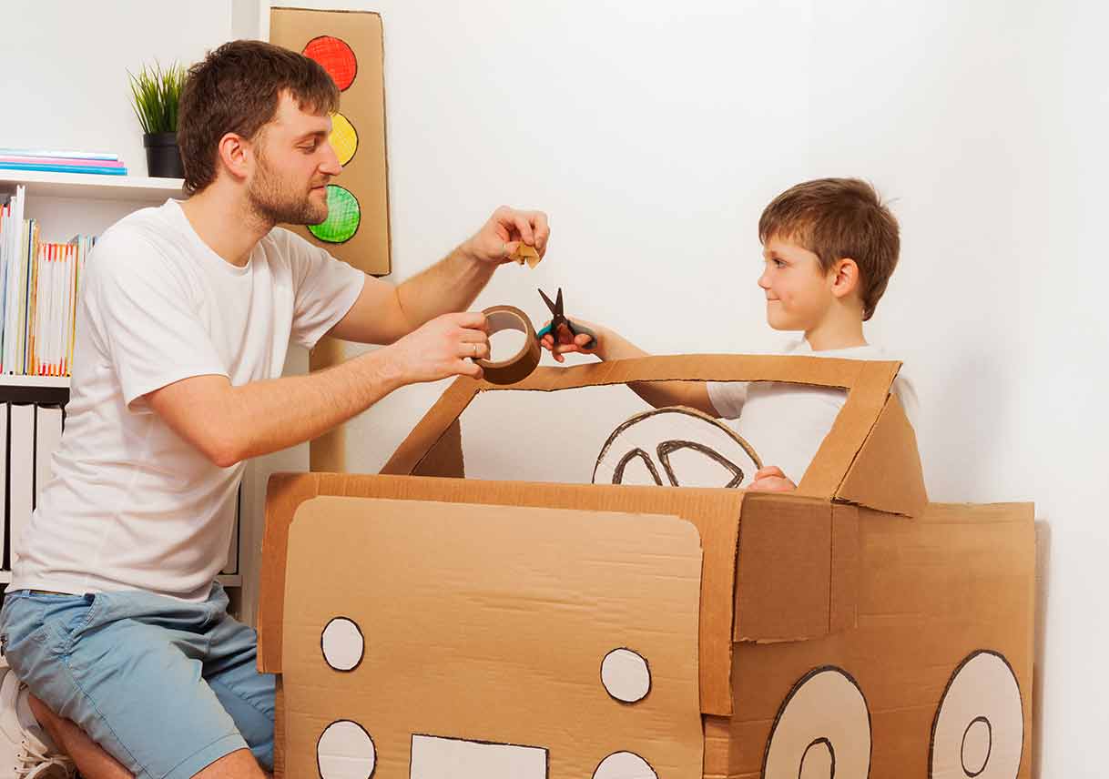 dad and son building cardboard box car