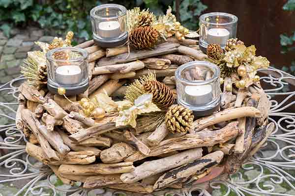 Christmas centerpiece with wood, pine cones, and four candles