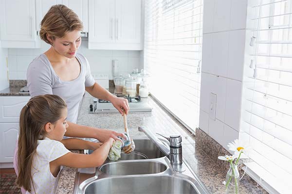 Mom and daughter wash dishes