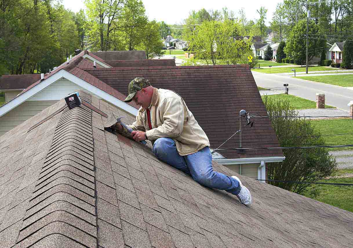 roofer repairing damaged shingles