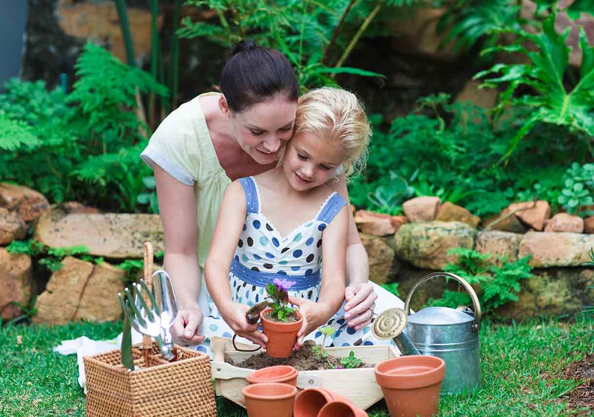 mother and daughter potting plants outside