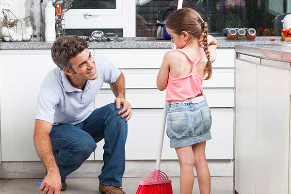 father helping daughter sweep