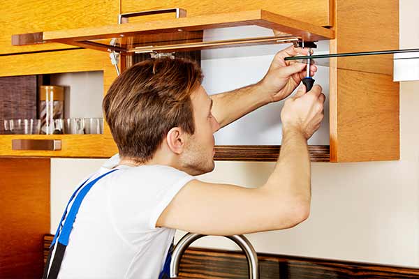 handyman repairing a cabinet