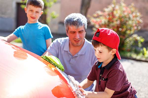 dad and sons washing car