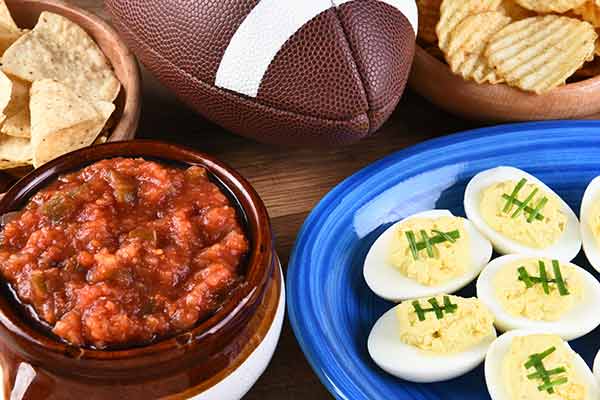 closeup of snacks on a table surrounding a football