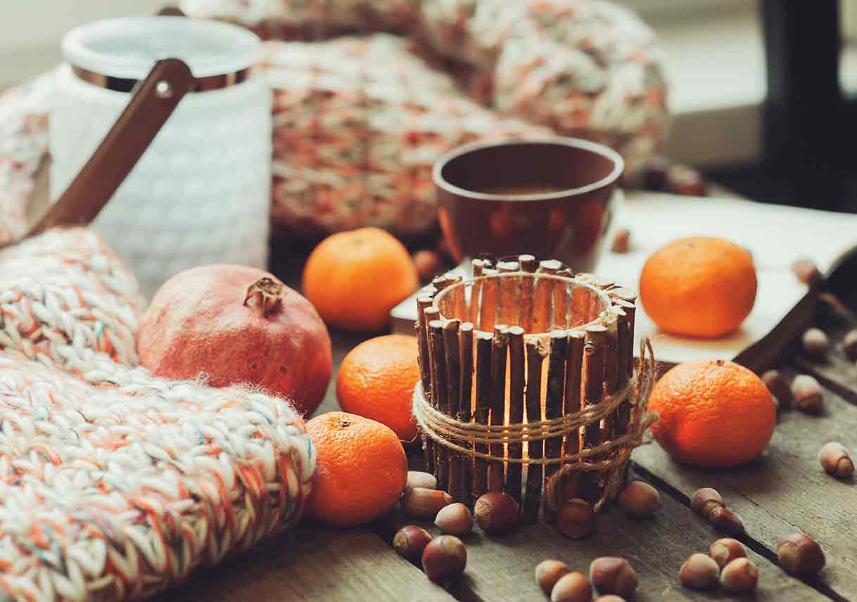 closeup of fruits, nuts, and a candle decorating a table