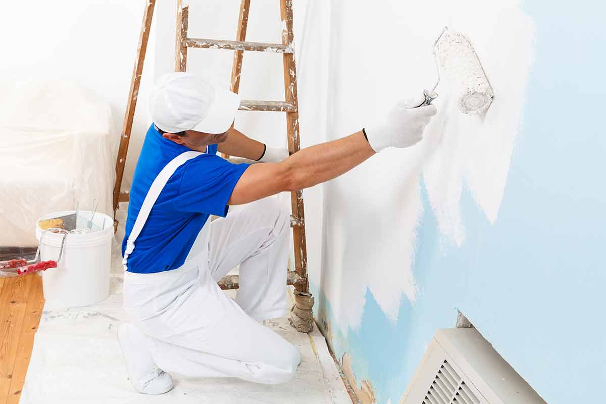 professional painter using water-based paint to paint a wall