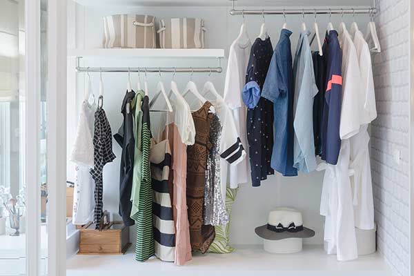 A white walled closet, filled with female apparel