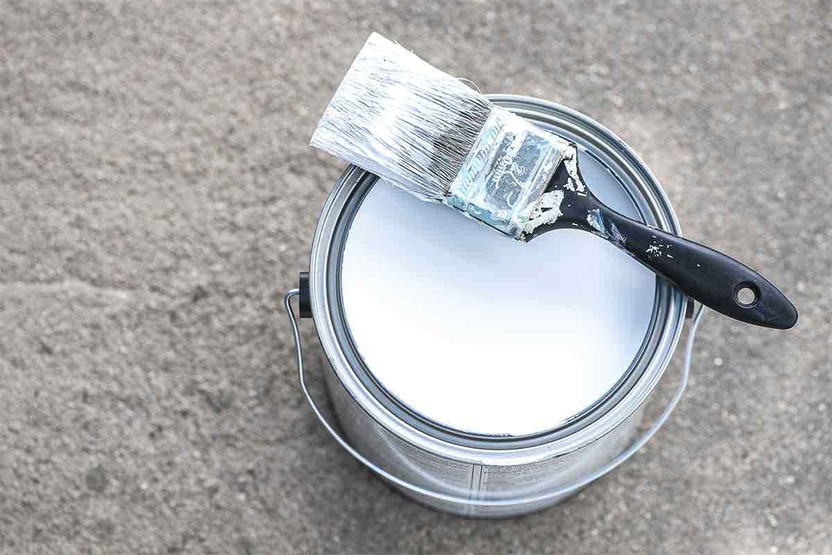 can of paint primer with brush