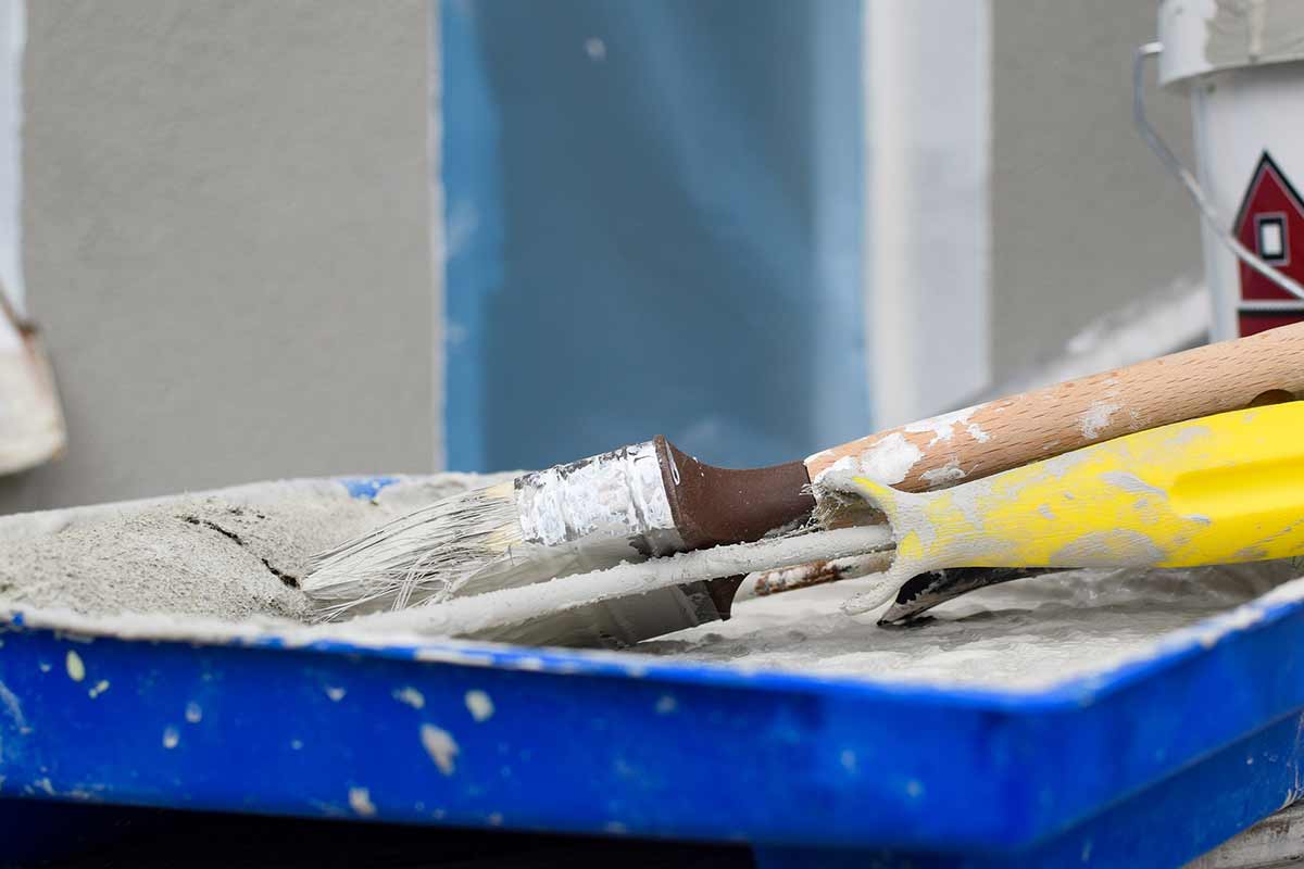 paint roller and brush in paint tray