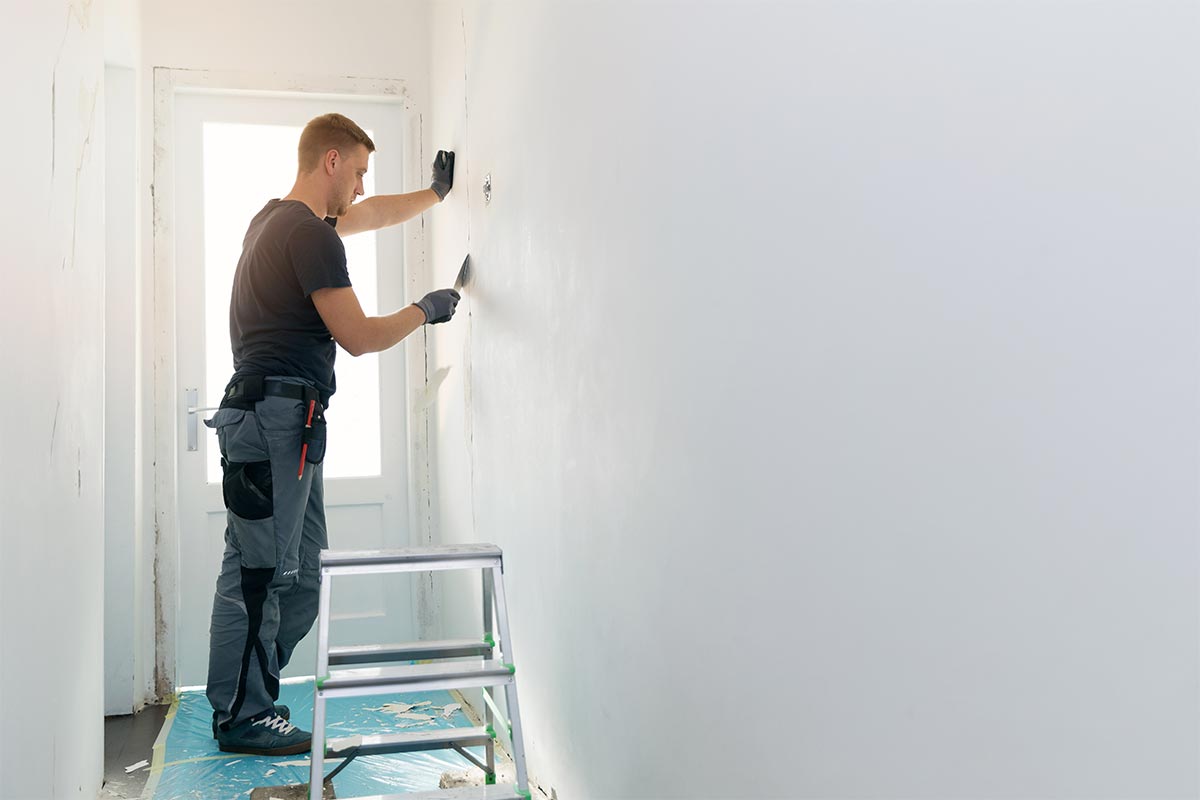 painter prepping wall for painting