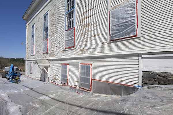 tarps around building with peeling paint