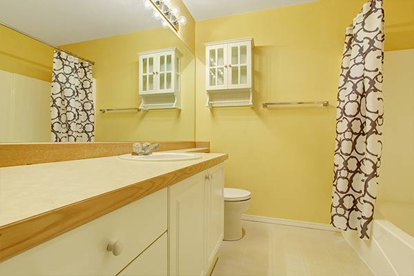 yellow bathroom with a wooden countertop