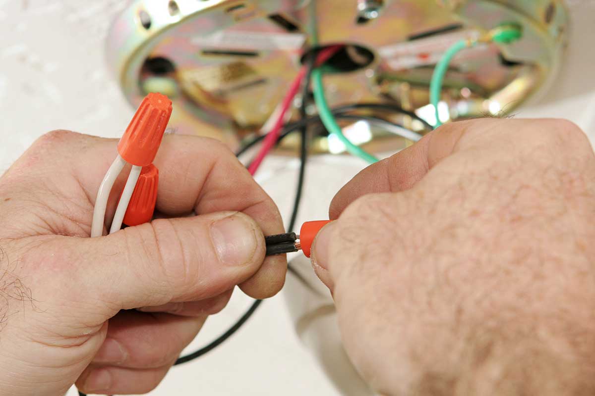 electrician connecting wires in a light fixture