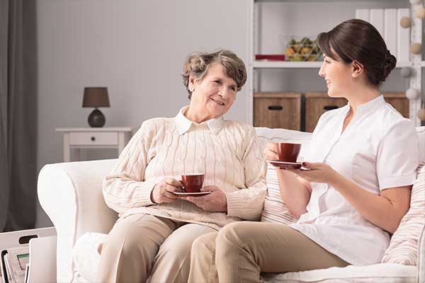 younger woman talking with older woman on couch