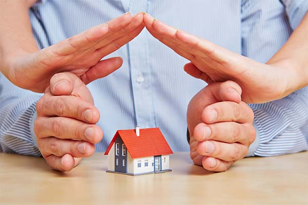 hands form house shape around small house