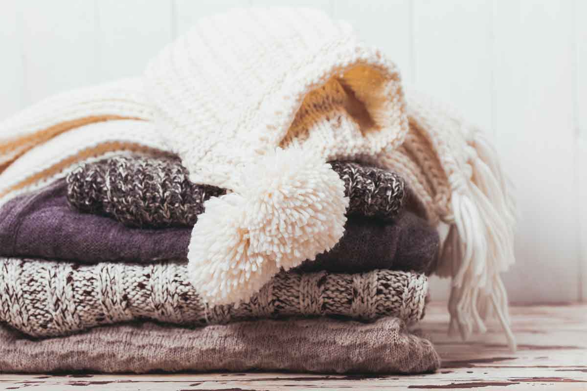 stack of folded sweaters and hats