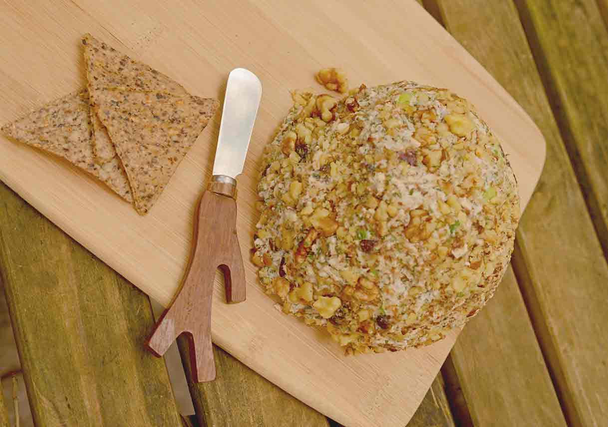 cheese ball and cheese spreader with crackers on wood table