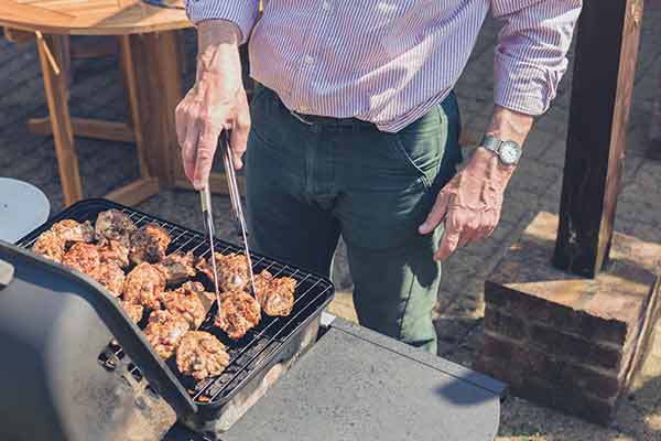 man grills chicken