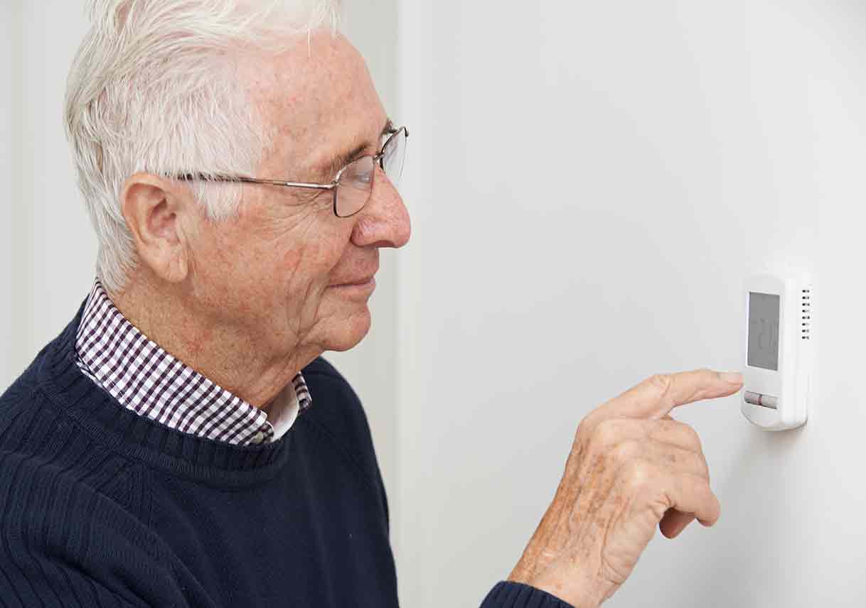 man adjusting thermostat