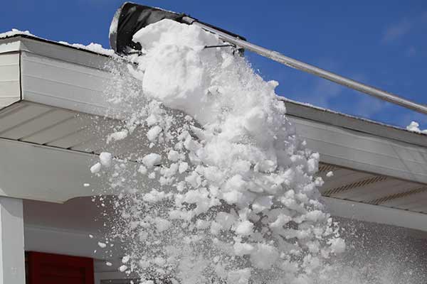 snowy roof being raked away