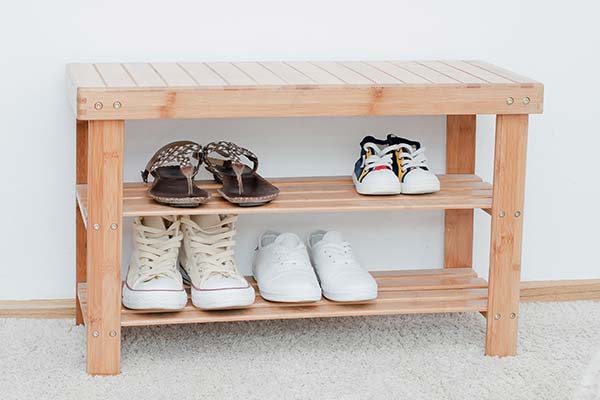 four pairs of shoes on wooden shoe shelf